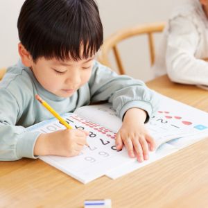 anak sedang menulis menggunakan pensil