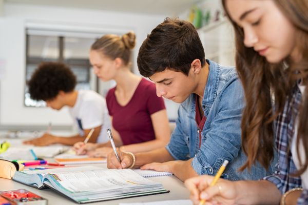 Para siswa aktif menulis pelajaran di ruang kelas